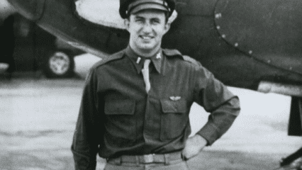 Leland Norton in military uniform standing in front of an aircraft.