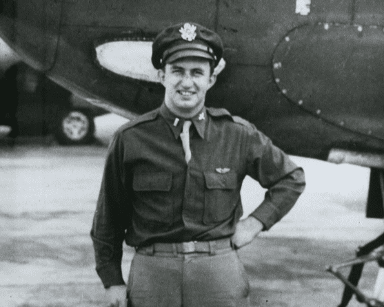 Leland Norton in military uniform standing in front of an aircraft.