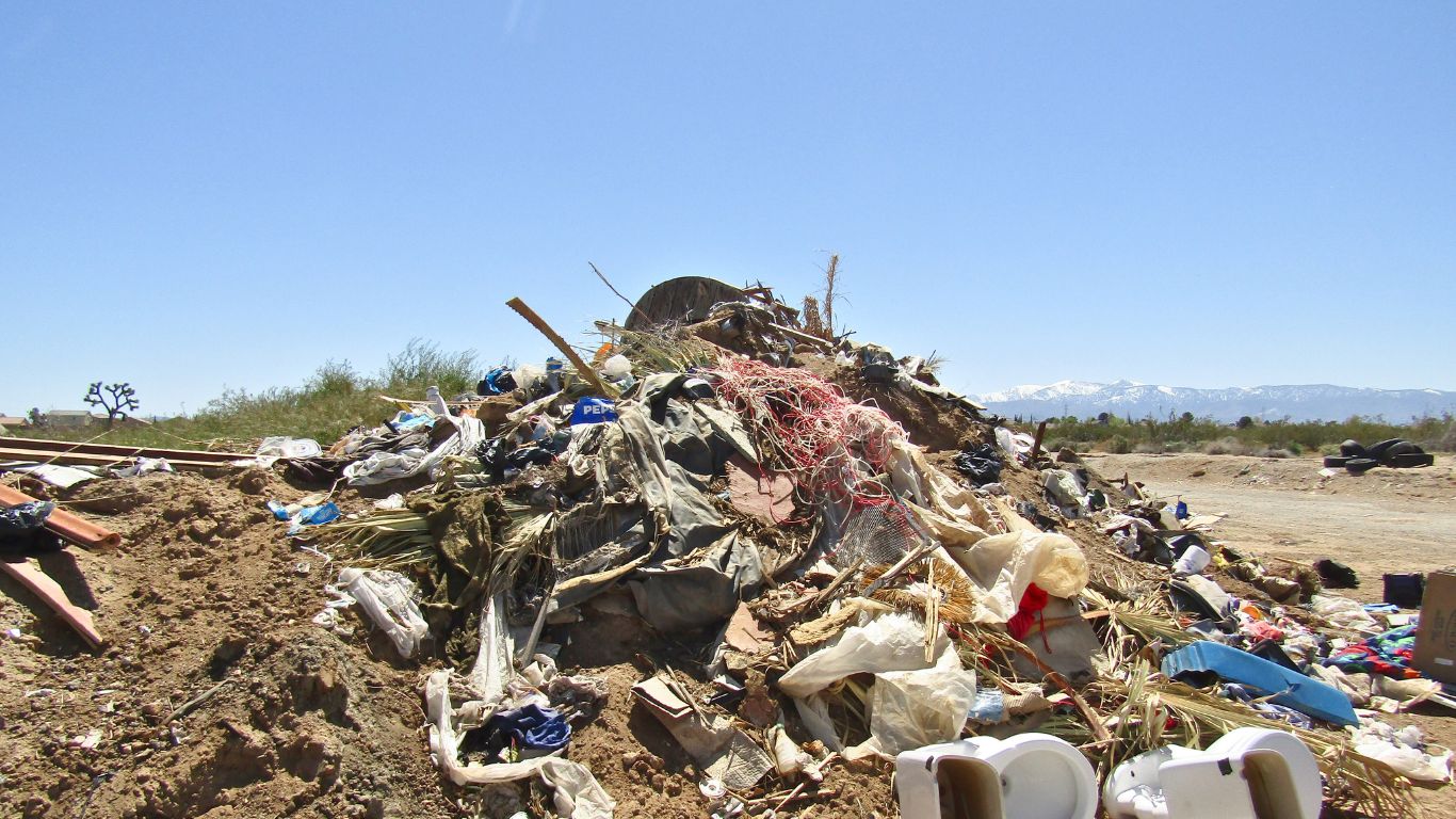 A mountain of trash piled high in the desert field.