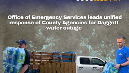A graphic of two County workmen carrying packs of bottled water in front of stacks of water and a county truck.