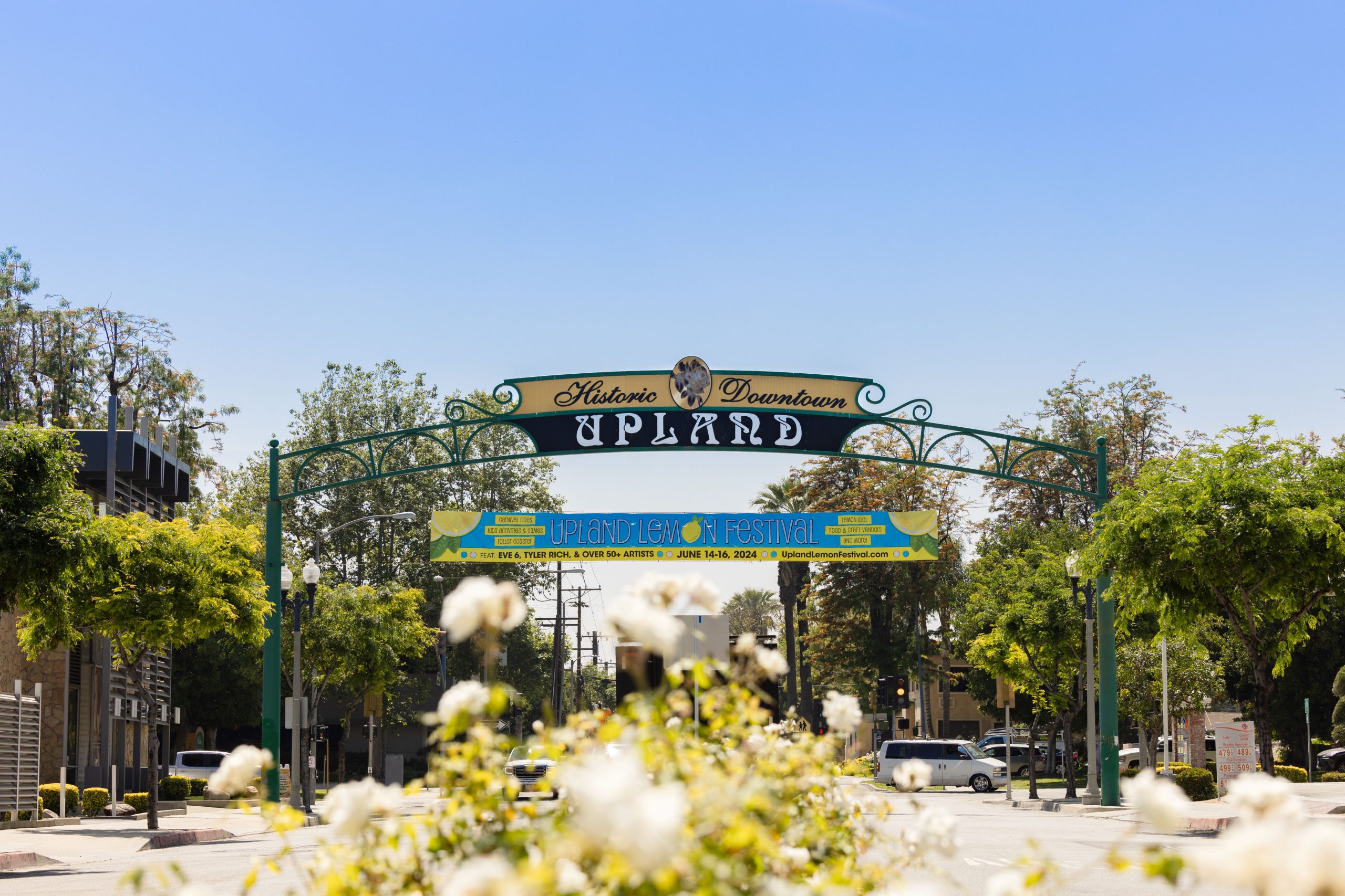 A photo of flowers and shop with a sign that say Historic Downtown Upland.