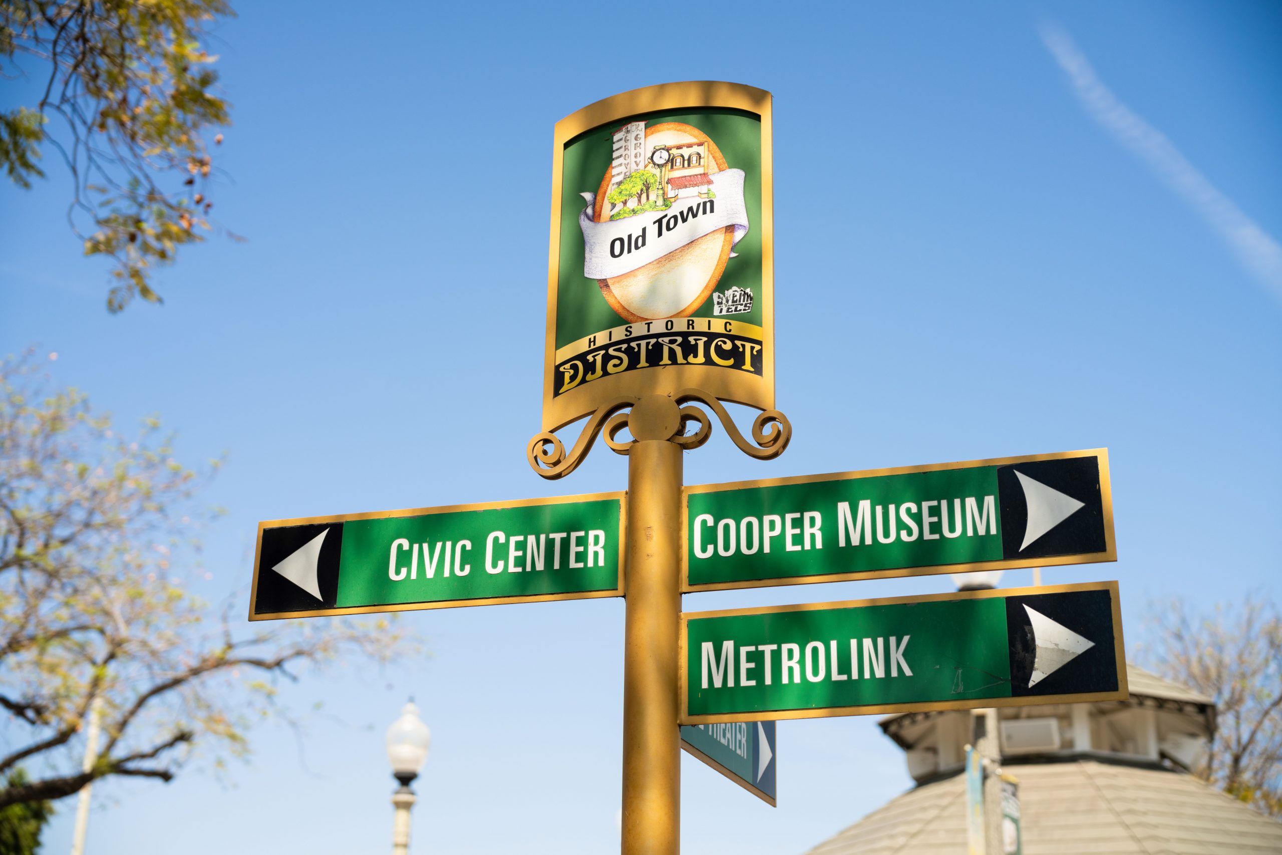 A photo of Old Town Upland signs pointing to the Metrolink, Museum and Civic Center.