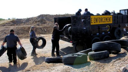 workers putting old tires in a truck