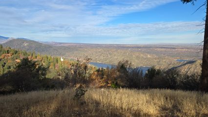 A view of the mountains with a lake in the background.