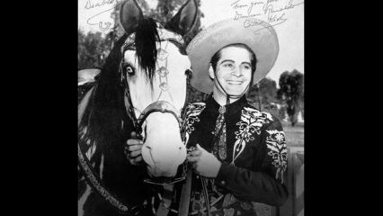 Picture of a cowboy holding on to his horse.