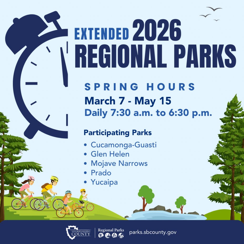 A background park setting with trees, grassy hills, lake with a family of four riding bikes with an illustration of a half alarm clock and the words Extended 2026 Regional Parks Spring Hours, March 7-May 15, daily 7:30 a.m. to 6:30 p.m. at participating parks Cucamonga-Guasti, Glen Helen, Mojave Narrows, Prado, Yucaipa with Regional Parks logo on the bottom with the parks’ website address, parks.sbcounty.gov.