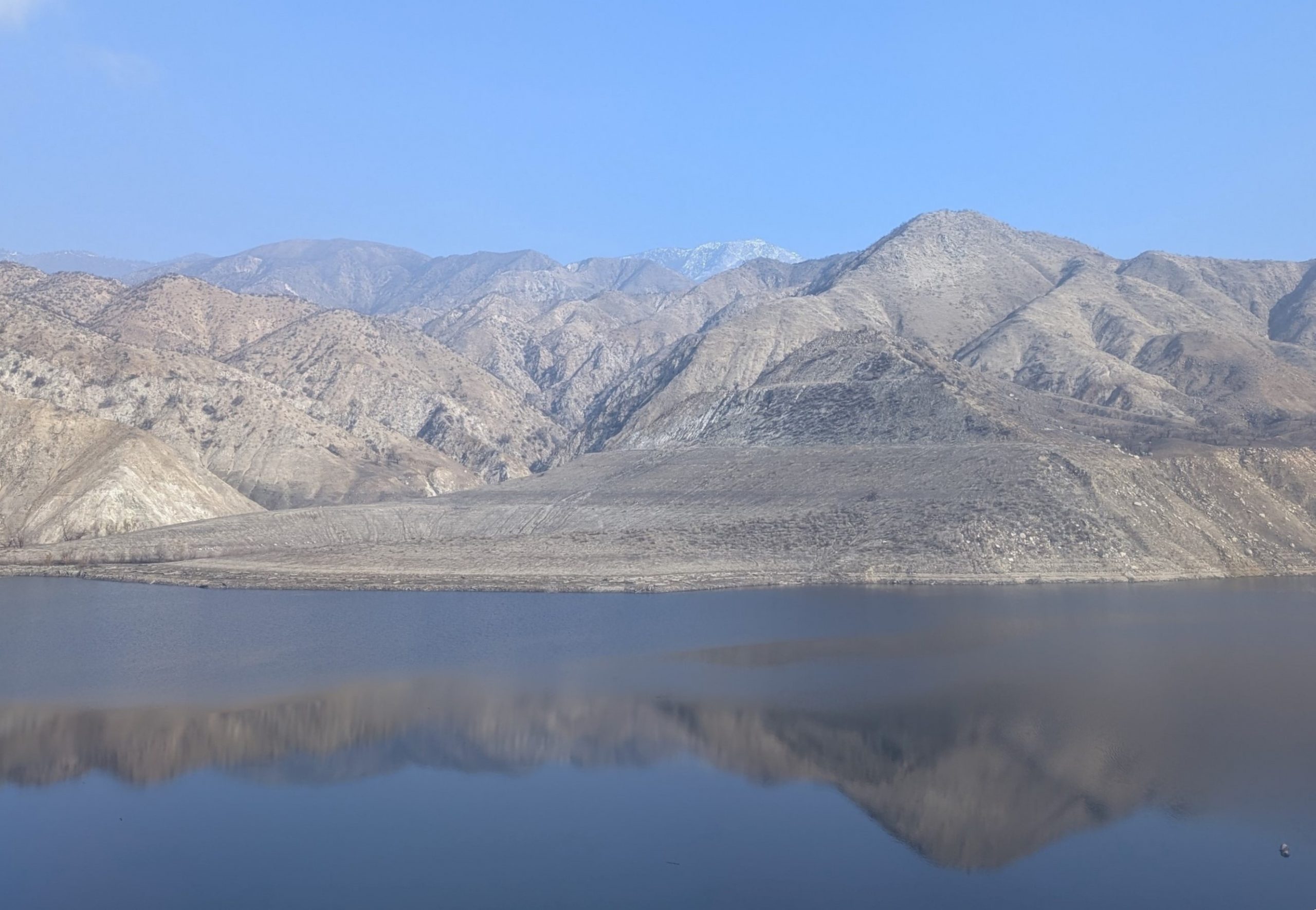 A view of a dam surrounded by mountains.