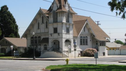 An exterior view of the Congregational Church located on a street corner.
