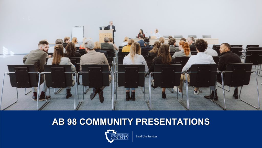 Attendees sitting in chairs in front of a podium at a presentation. Image also features the San Bernardino County Land Use Services logo.