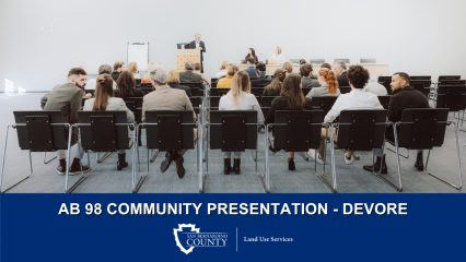 A speaker addresses a seated audience. Text: “AB 98 Community Presentation – Devore" and San Bernardino County Land Use Services logo.