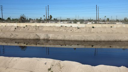 View of the Santa Ana River with utility poles in the background.