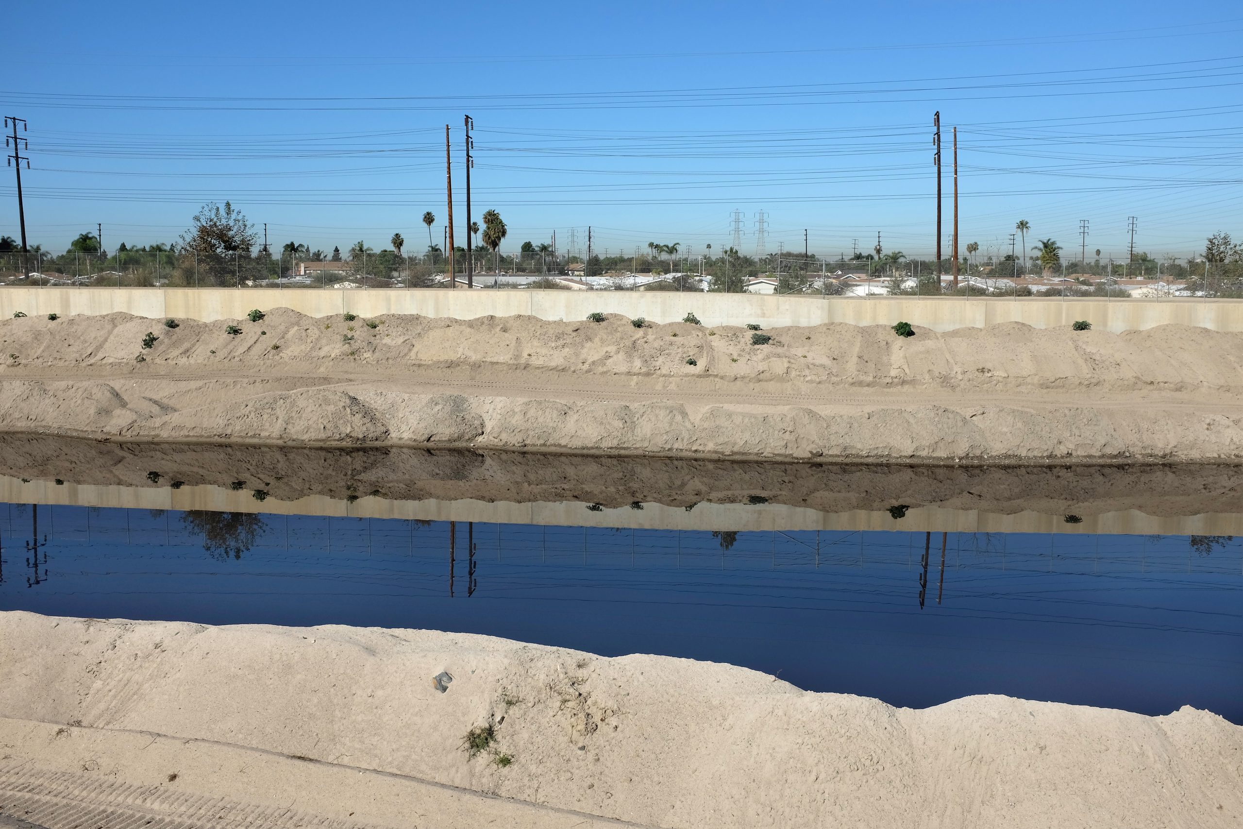 View of the Santa Ana River with utility poles in the background.