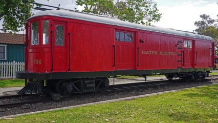 A red Pacific Electric Railway car on train tracks.