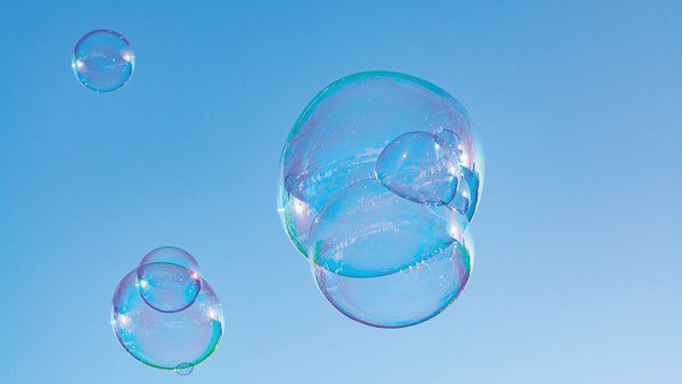 Many soap bubbles in air, blue sky, outdoor fun for everybody.
