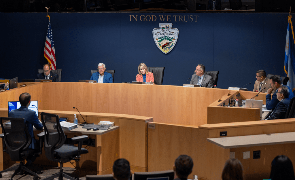 San Bernardino County Board of Supervisors seated at a dais with other county officials seated around the dais.