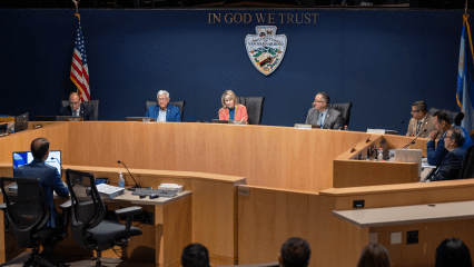 San Bernardino County Board of Supervisors seated at a dais with other county officials seated around the dias.