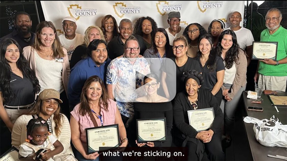 A group of people sitting and standing holding certificates.