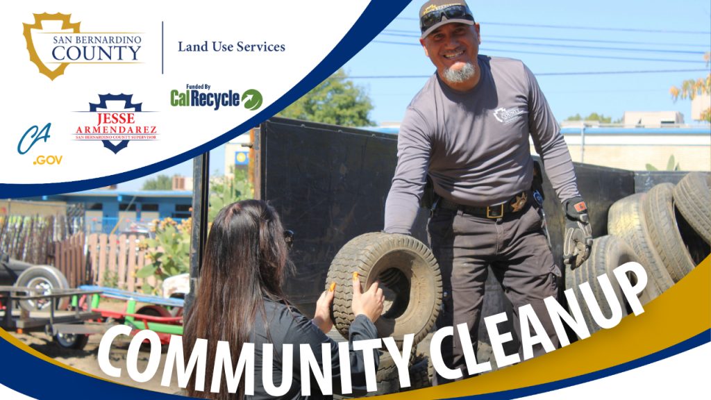 County staff load used tires onto a truck as part of a community cleanup event. Logos of the organizations coordinating the event are shown, including San Bernardino County Land Use Services.