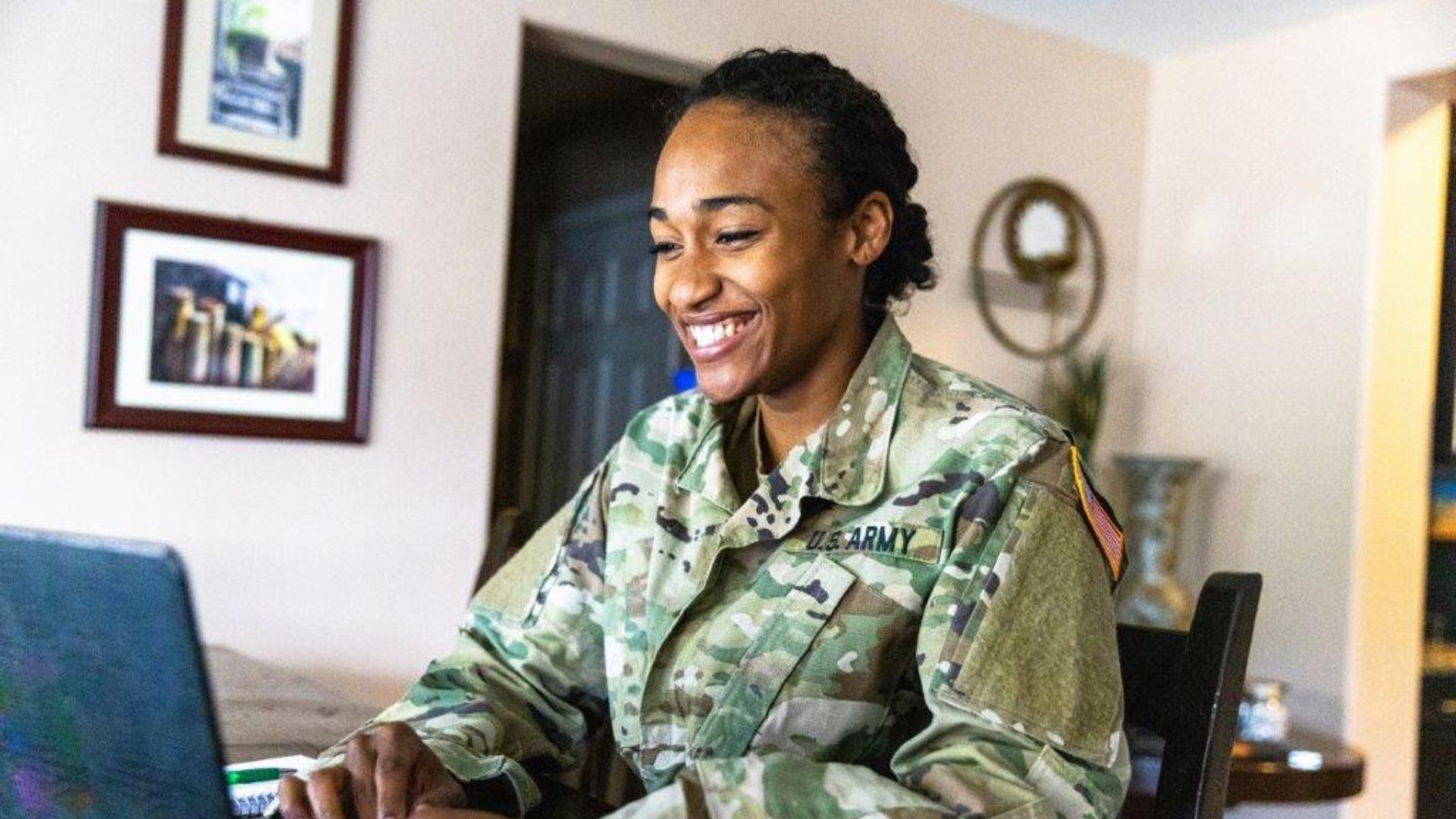 A person in military uniform using a computer.