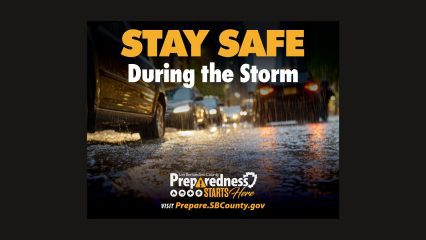 A graphic from San Bernardino County showing a flooded street during heavy rain with text that says “Stay Safe During the Storm” and the Preparedness Starts Here logo. Visit Prepare.SBCounty.gov for more information.