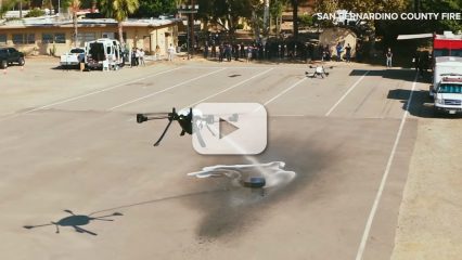 A drone sprays water on an a object in a parking lot.