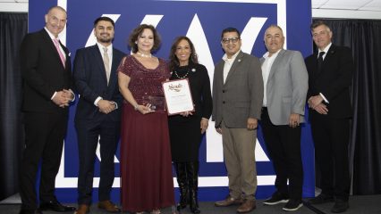 Several officials pose with a CSAC award and State Senate certificate for San Bernardino County’s Emprendedor@s program, smiling in front of a CSAC backdrop.