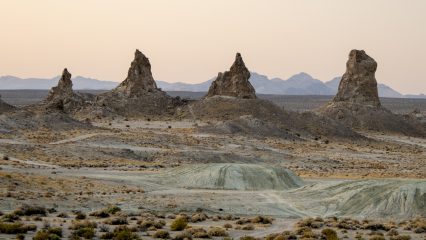 View of the Trona Pinnacles at sunset with mountains in the background.