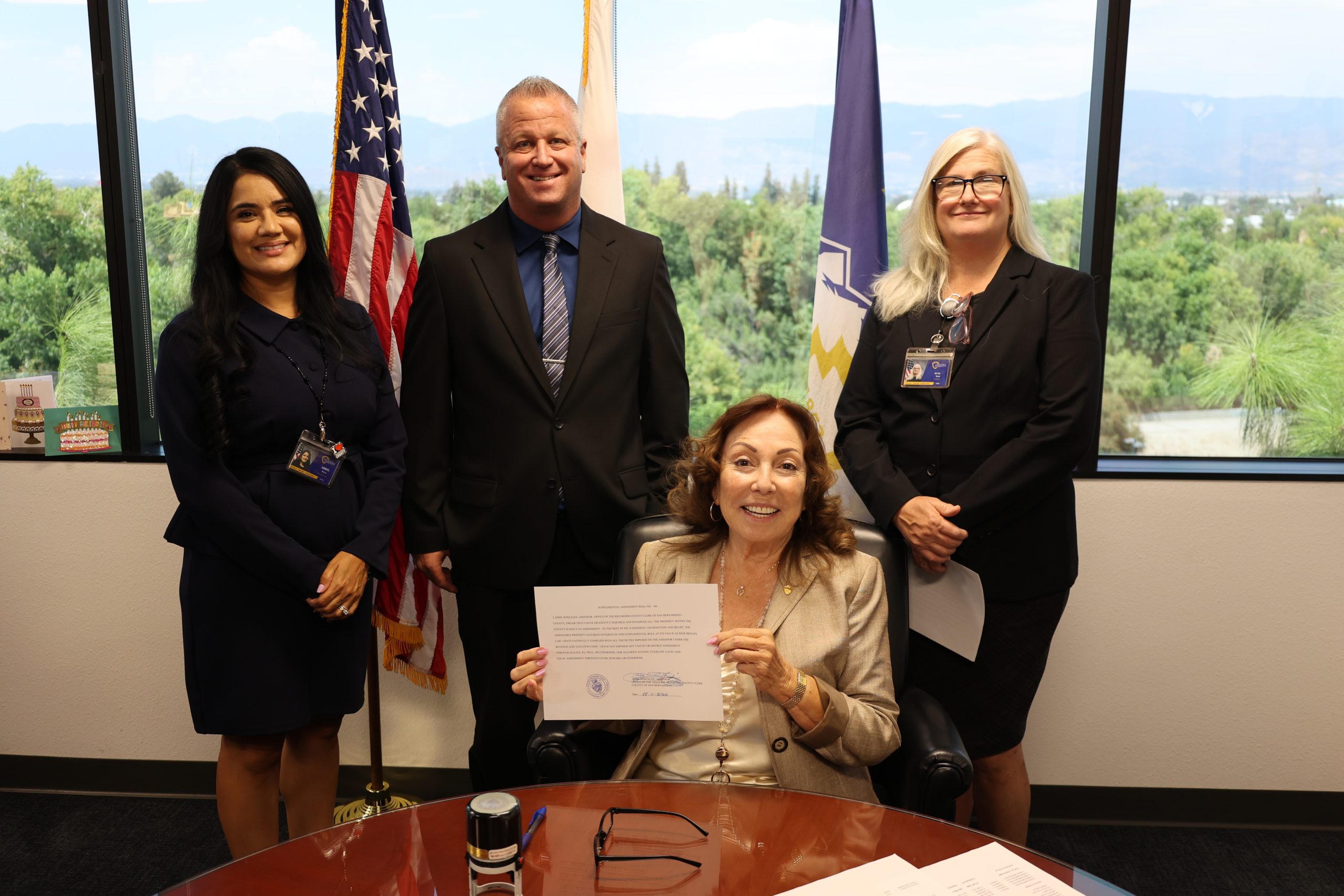 Four County staff pose as Assessor-Recorder-County Clerk Josie Gonzales holds supplemental roll #140.
