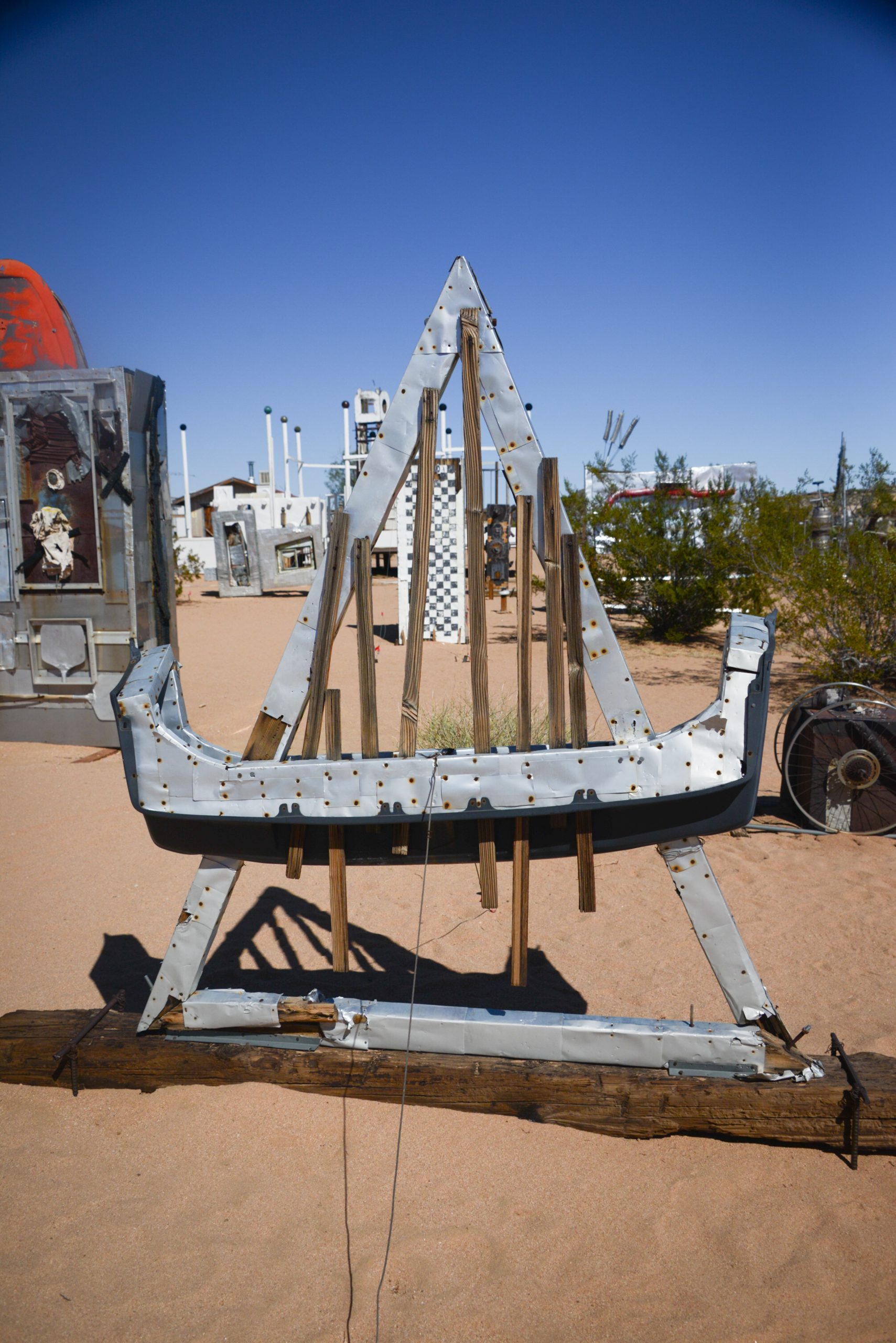 View of the Noah Purifoy's Outdoor Desert Art Museum exhibit featuring a small wooden structure with bicycles on its roof.