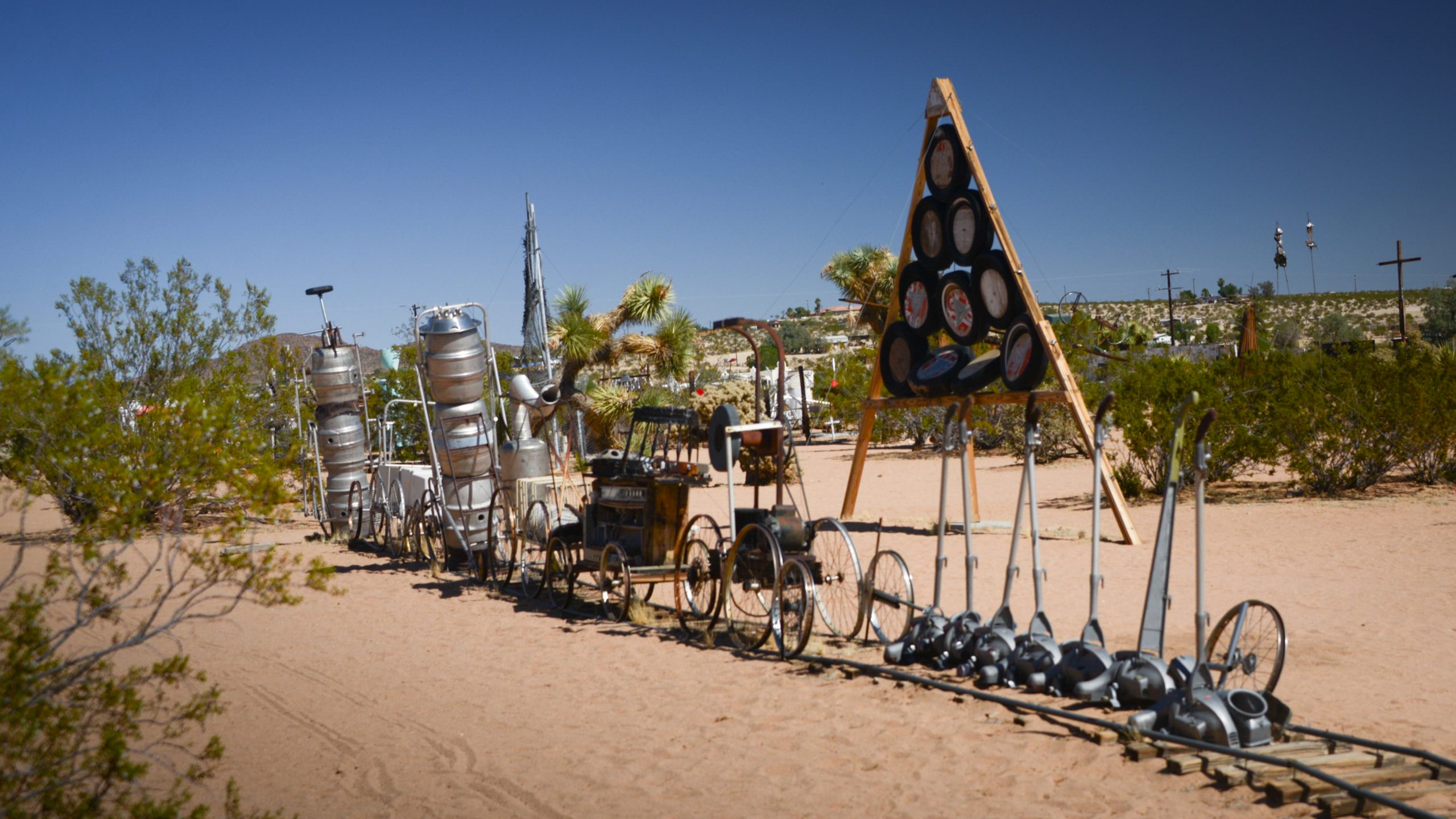 View of the Noah Purifoy's Outdoor Desert Art Museum exhibit featuring sculptures made from metal objects and bicycle parts.