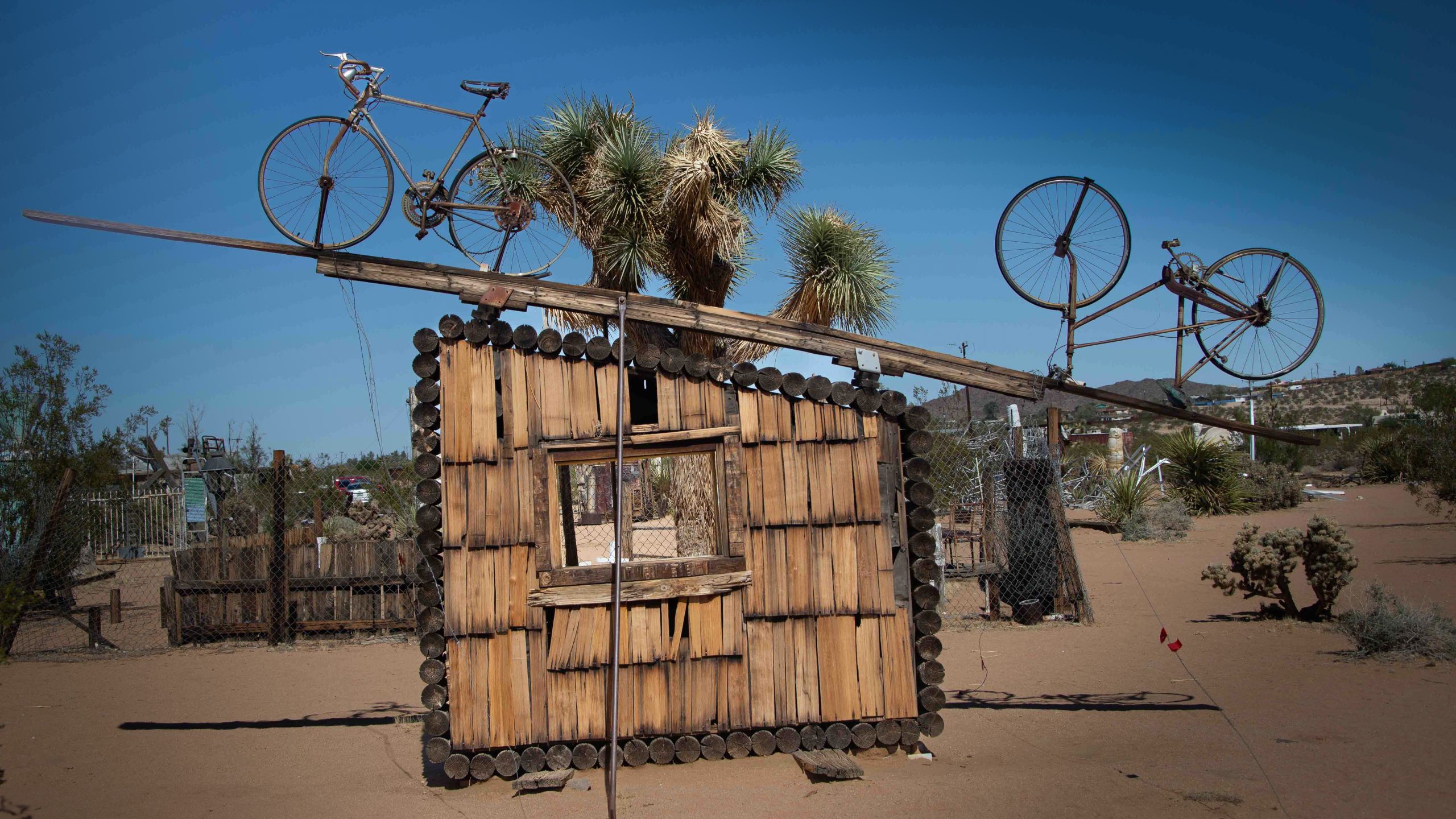 View of the Noah Purifoy's Outdoor Desert Art Museum exhibit featuring sculptures made from metal objects and bicycle parts.