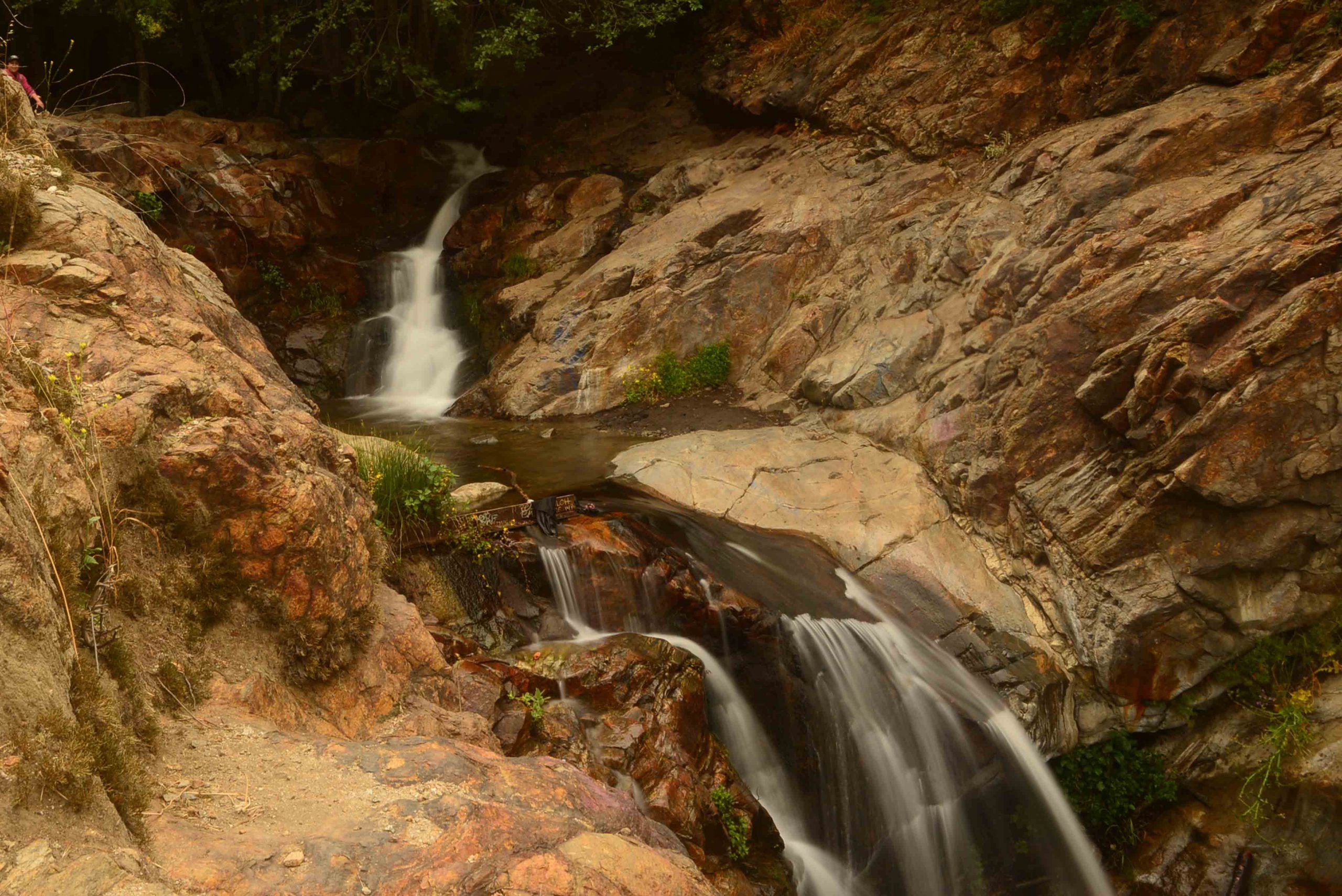 A waterfall flowing over brown rocks.