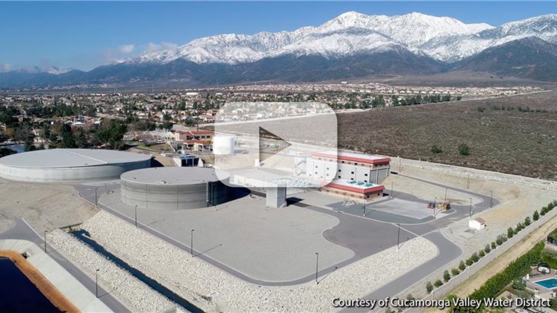 Aerial view of the Cucamonga Valley Water District facility with snow-capped mountains in the background.
