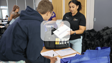 Children and Family Services staff give foster youth a tablet, with a video play button overlay, indicating a video.