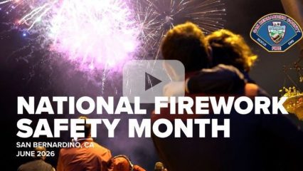 Crowd viewing fireworks display and text: National Firework Safety Month, San Bernardino, June 2026, with a play button overlay indicating a video.