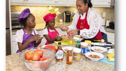 A woman and two girls in a kitchen cooking healthy food.