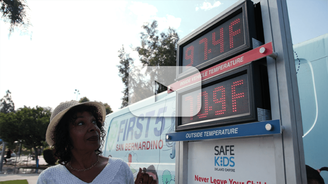 Karen Scott, executive director of First 5 San Bernardino, looks at outdoor thermometer depicting rising temperatures inside a vehicle.