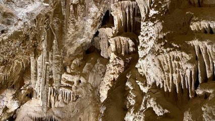 A view of natural tone stalactites and stalagmites inside a limestone cave.