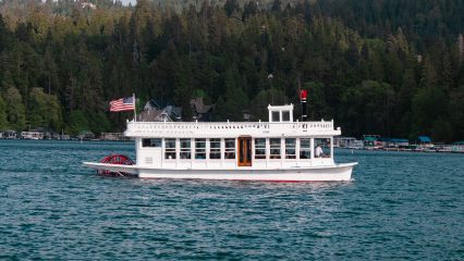 A boat sailing on a lake with a forest in the background.