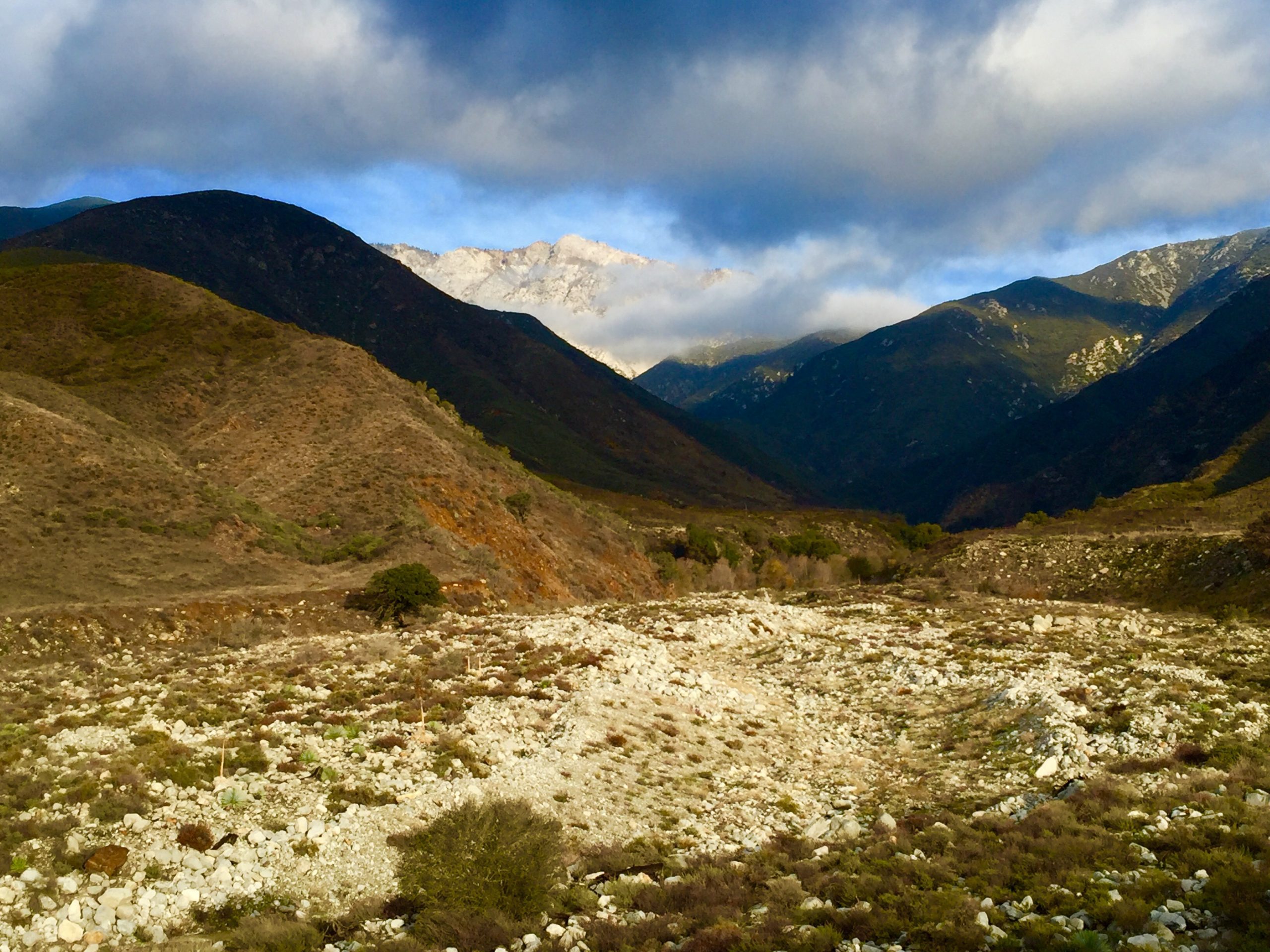 A view of mountainous terrain under a partly cloudy sky.
