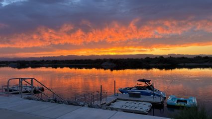 View of the Colorado River at sunset with a boat at a docking station.