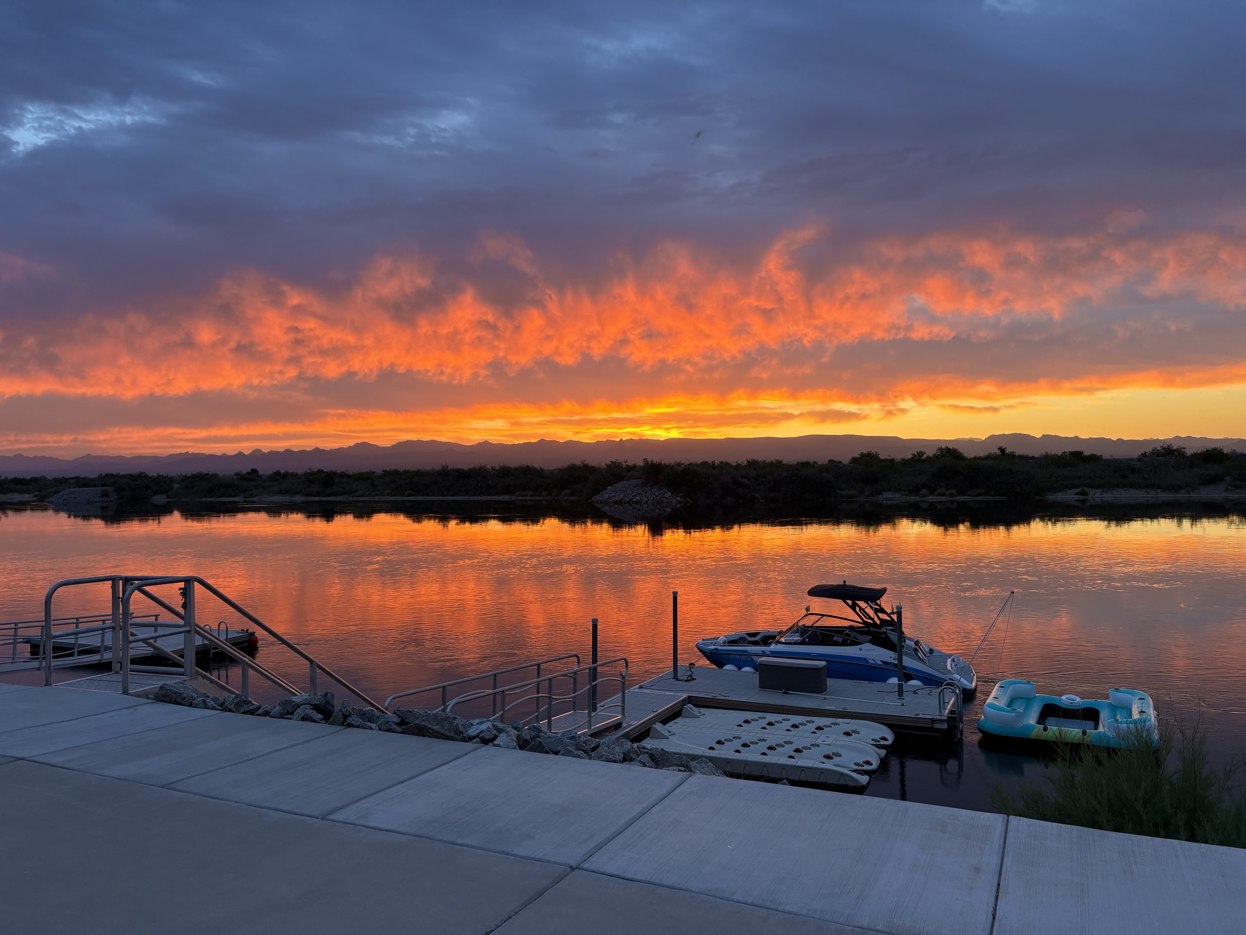 View of the Colorado River at sunset with a boat at a docking station.