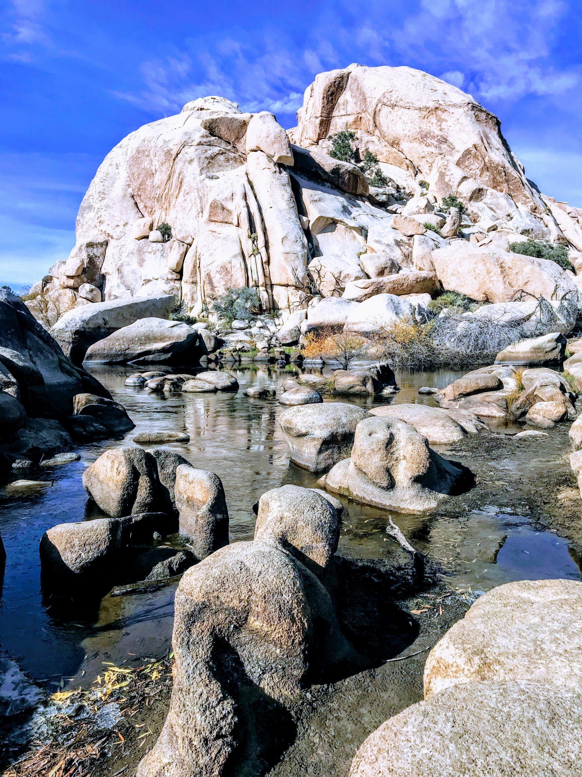 Large boulders with a stream of water below them.