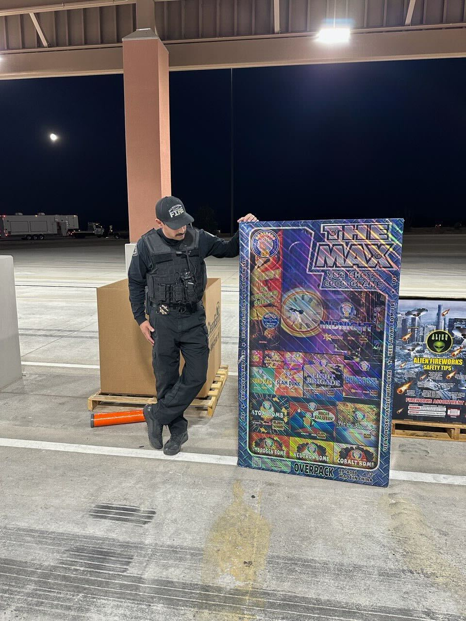 A San Bernardino County Fire investigator stands beside a large assortment of illegal fireworks seized during interdiction operations aimed at reducing fire danger and injury risk.