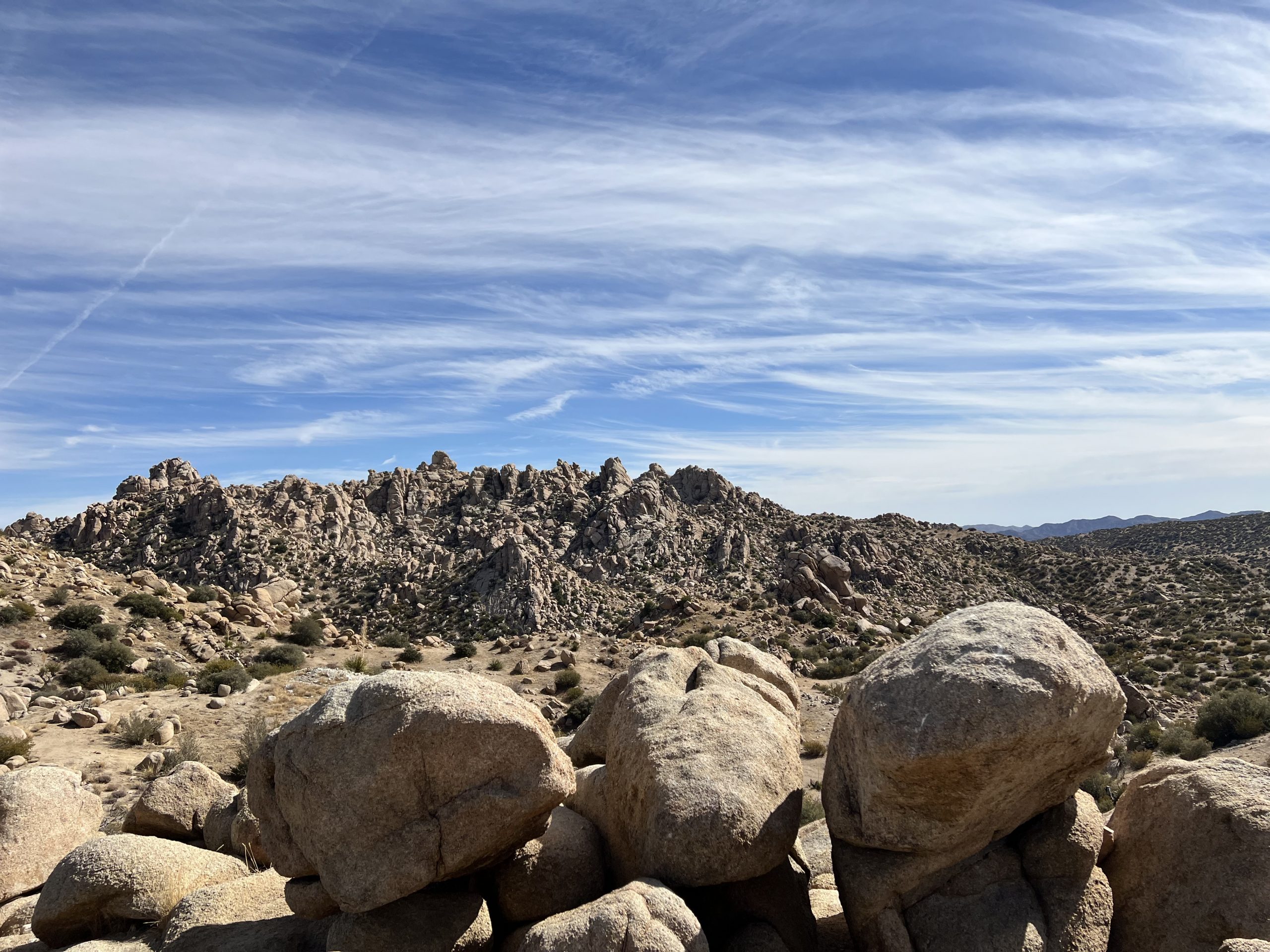 View of rocky terrain and large boulders under a clear blue sky at the Pioneertown Mountains Preserve.