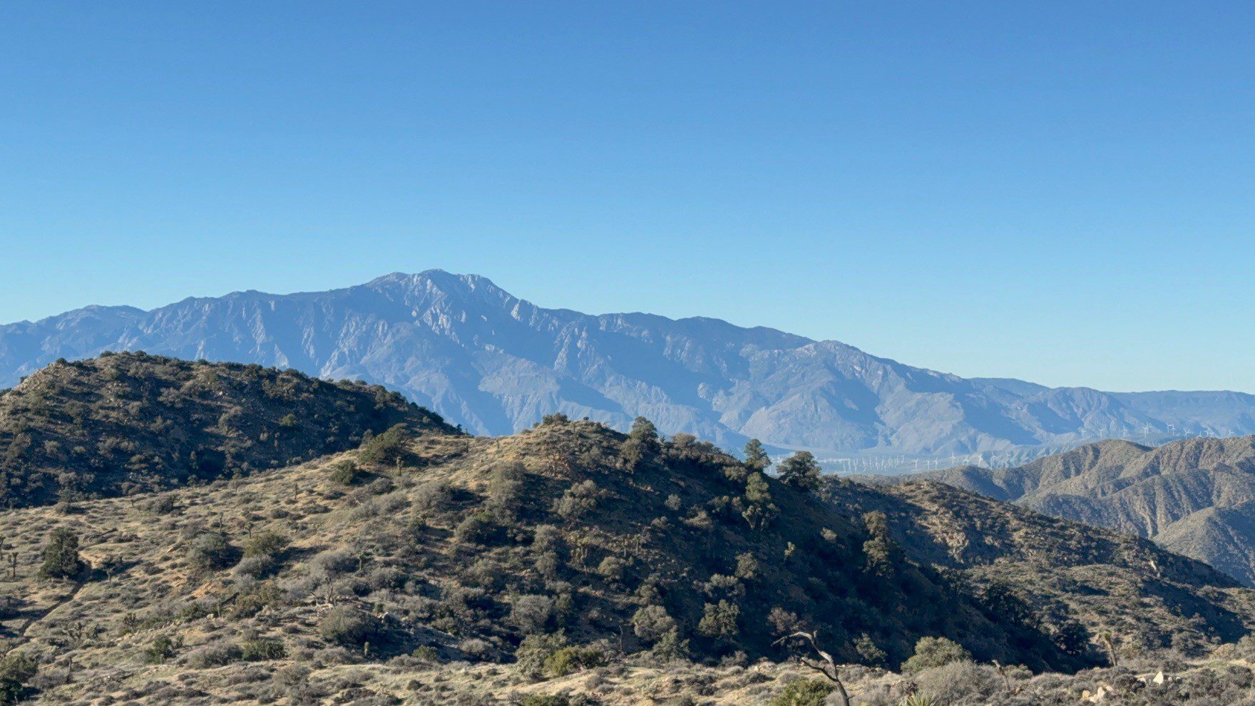 View of some hills in the foreground and mountains in the background.
