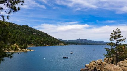 View of Big Bear Lake with boats on the water and mountains in the background.