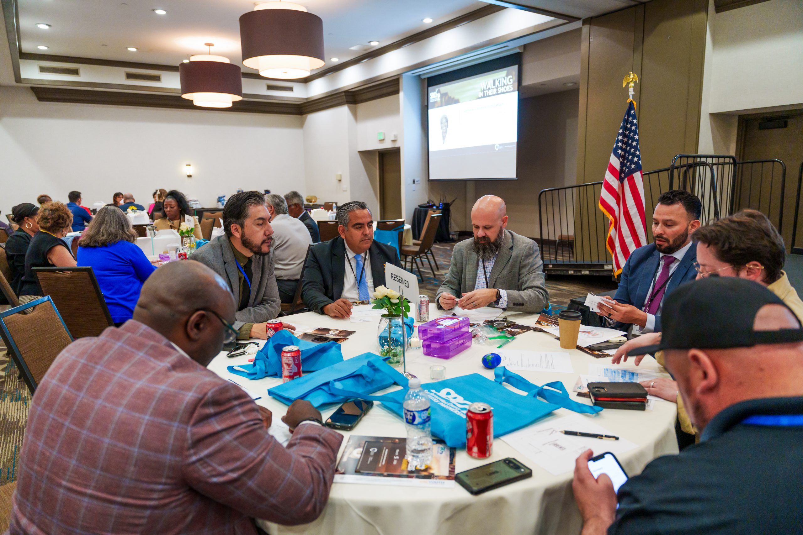 A table with several people and one person reading from a note card.