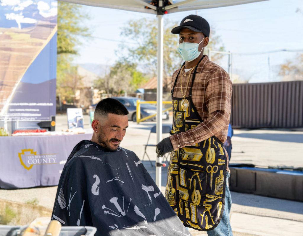 A man giving a haircut to another man. 