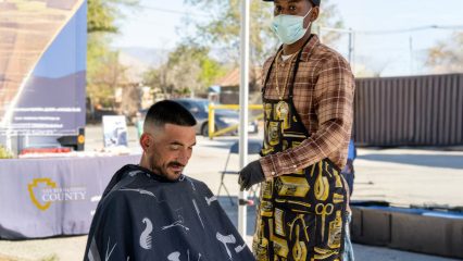 A man giving a haircut to another man.